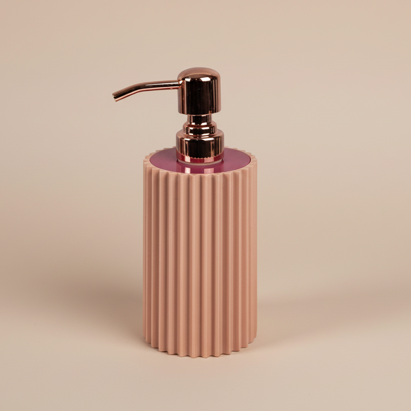 Pink ribbed soap dispenser with rose gold pump on a beige background