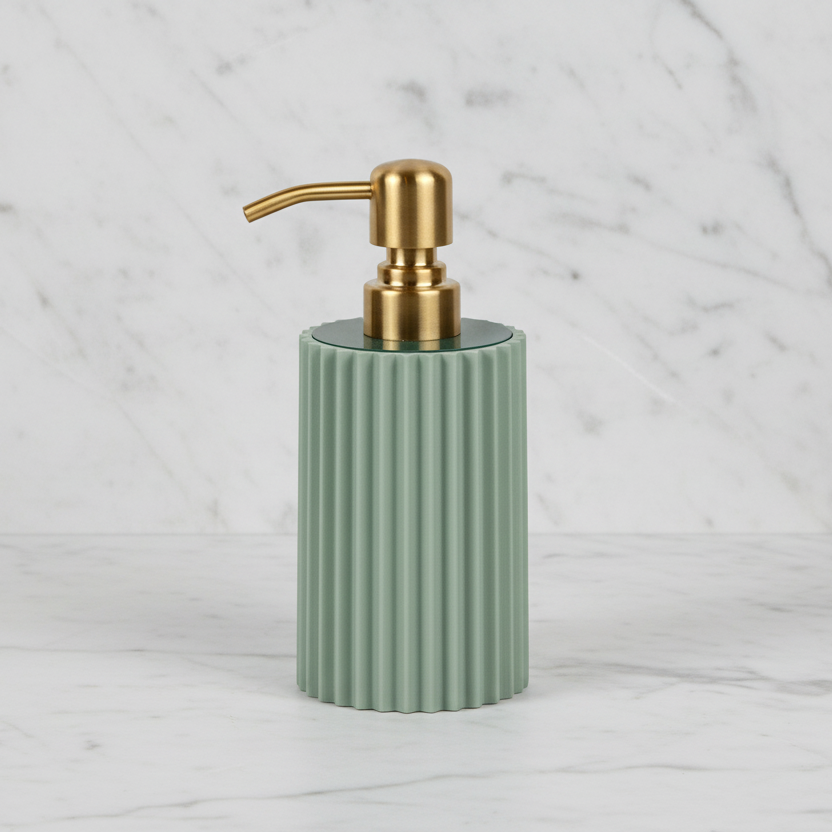 Green soap dispenser with gold pump on a marble background