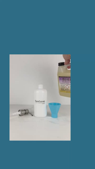 instructional video of a person attaching a funnel to a bottle and pouring hand soap through it into a white bottle.